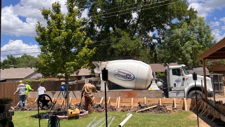 Alanis crew pouring a concrete slab with a mixer truck on site