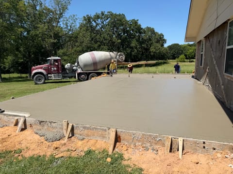 Freshly poured concrete slab beside a home