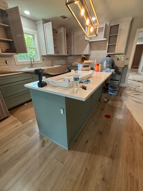 Sage green island under lantern pendants