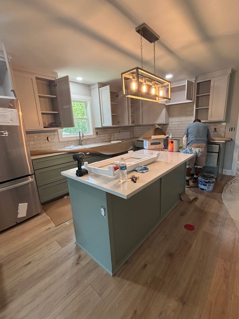 Kitchen remodel in progress with wide plank flooring