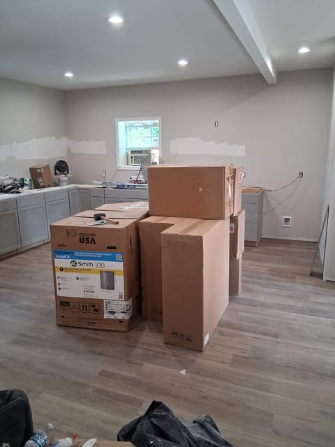 Kitchen cabinets and appliances being installed in a new build