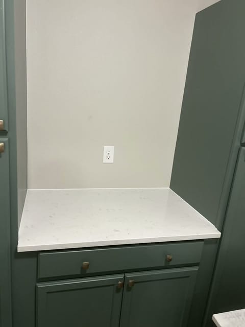 Custom green pantry cabinets with quartz counter