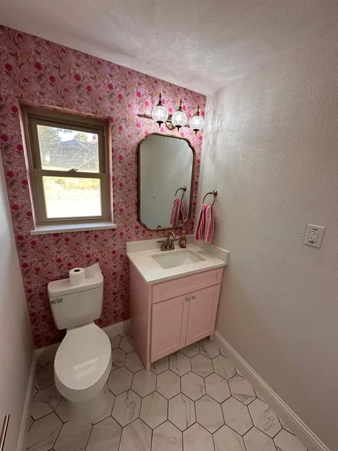 Designer powder bath with floral wallpaper and brass