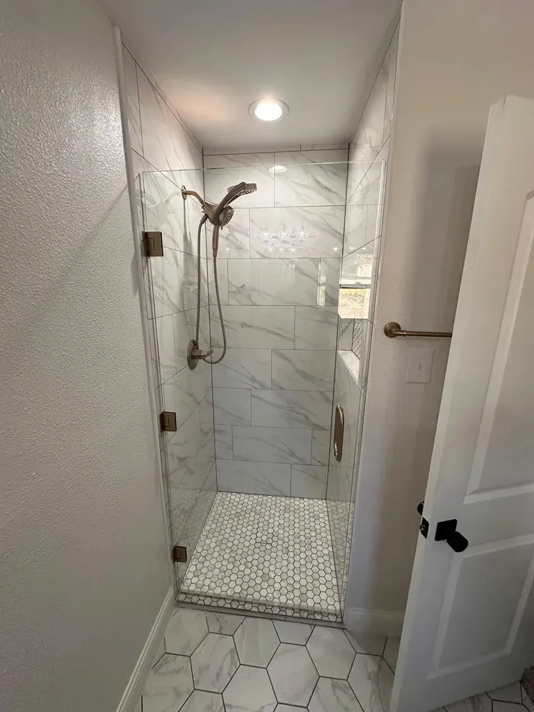Marble walk-in shower with brass fixtures